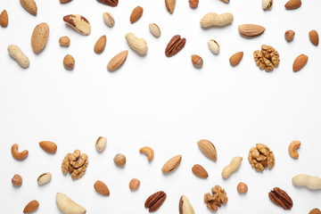 Different delicious nuts on white background, flat lay. Space for text
