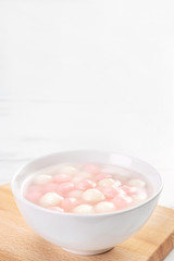 Fototapeta na wymiar Tang yuan, tangyuan, delicious red and white rice dumpling balls in a small bowl. Asian traditional festive food for Chinese Winter Solstice Festival, close up.