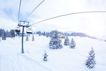 Ski lift over magnificent snow covered fir forest on Alpine mountain resort - Powered by Adobe