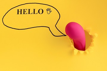 Sex toy for adult, dildo vibrator looking through a hole in the yellow paper with text hello. Funny...