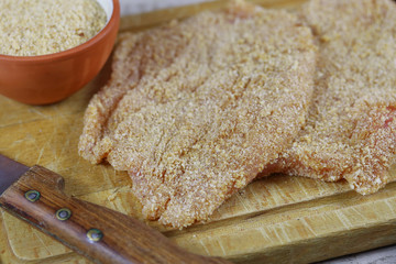 escalope de volaille panées sur une planche à découper