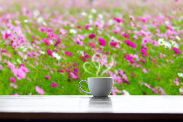 Hot coffee cup of love on table blurred flower background.Valentine's day concept.