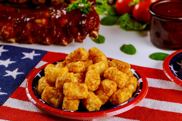 Party table with tater potatos and BBQ ribs for Independence Day.
