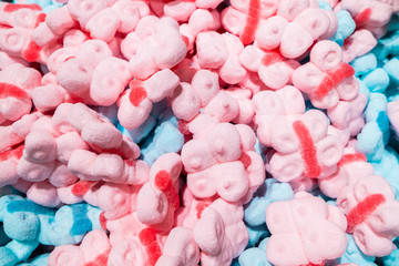 Fresh fragrant pieces of yellow marmalade in the form of butterflies in a large pile lie on the counter of the store. Beautiful tasty treat made from natural ingredients.