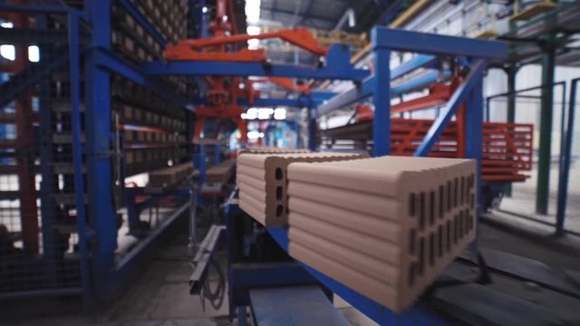 Grey bricks are moving on a manufacturing line on the fully automated factory