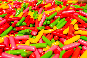 Abstract multicolored background made of many colorful sweet sticks of chewing sweets in icing. A tasty and healthy delicacy made from gelled fruit juice.