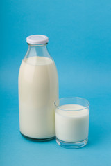 Dairy products. Bottle with milk and glass of milk on blue background .