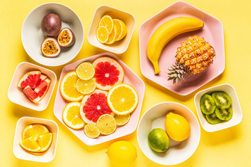 Tropical fruits whole and slices on plates