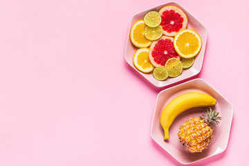 Tropical fruits whole and slices on plates