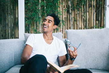 Young man laughing sitting on sofa