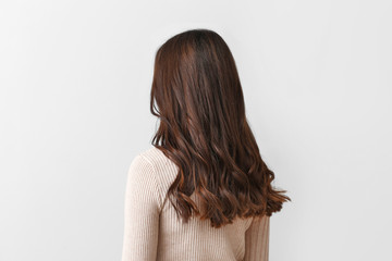 Young woman with beautiful hair on light background