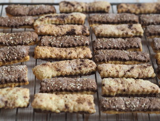 Homemade shortbread puff pastry chocolate cookies on a wooden background. On a grate for cooling.