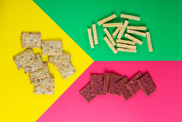 Crispbreads assortment for healthy nutrition on the multicolored background, Flat lay with snacks