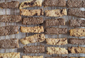 Homemade shortbread puff pastry chocolate cookies on a wooden background. On a grate for cooling.