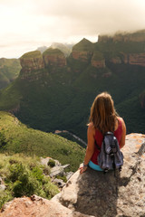 female hiking tourist sitting on mountains and enjoying the view
