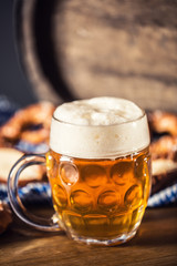 Oktoberfest beer with pretzel wooden barrel and blue tablecloth