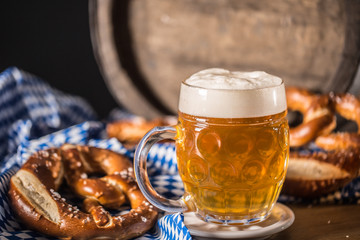 Oktoberfest beer with pretzel wooden barrel and blue tablecloth