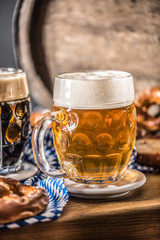 Oktoberfest beer with pretzel wooden barrel and blue tablecloth