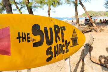 yellow surfboard sign leading to the surf shack