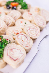 Ham roll ups on platter finger food buffet meal concept.