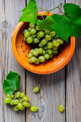 Grapes in a yellow bowl on the wooden table