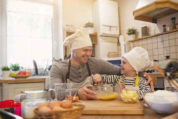 Dad and son in chef's hats are cooking