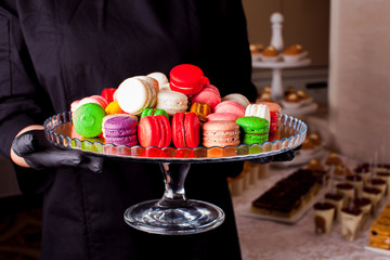 Colorful macaroons and other desserts served on the table