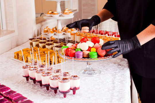 Colorful macaroons and other desserts served on the table