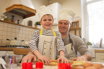 Dad and son in chef's hats are cooking