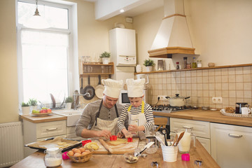 Dad and son in chef's hats are cooking