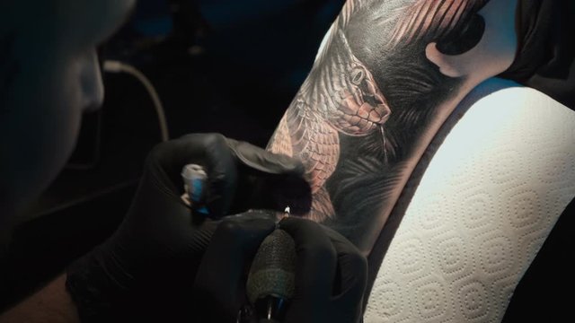 Close up video of man doing black tattoo in studio