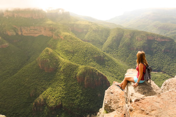 female hiking tourist sitting on mountains and enjoying the view