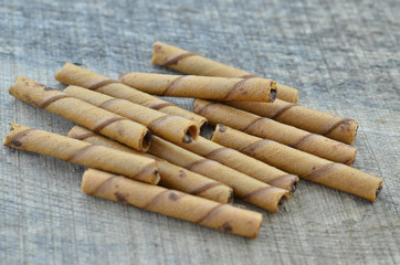 Chocolate waffle roll sticks on wooden background