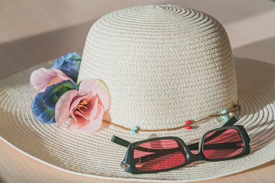 Sunglassess and summer straw hat symbolize vacations and traveling to warm countries. Color photo and copy space.