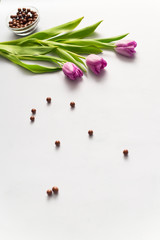 Purple tulips and candies on bright background. Decorations and background.
