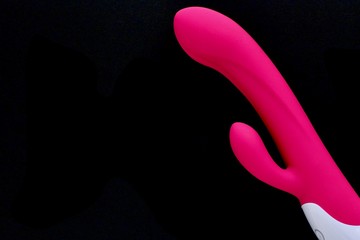 Sex toy for adult, design pink dildo vibrator isolated on black background. Concept of sex,...