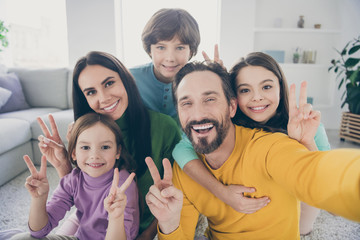 Obraz premium Self-portrait of nice attractive big full cheerful cheery glad family pre-teen kids mom dad having fun showing v-sign at cozy comfortable light white interior style house apartment