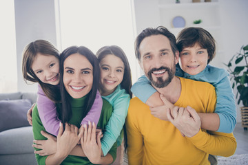 Close-up portrait of nice attractive charming idyllic ideal friendly careful cheerful cheery family three pre-teen kids mommy daddy embracing enjoying at light white interior style house living-room