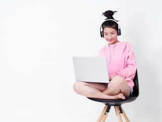 Cheerful girl using laptop sitting on chair.