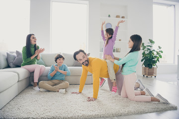 Nice attractive cheerful cheery excited glad adorable friendly family three pre-teen kids having fun playing spending free time at cozy comfortable light white interior style house flat living-room
