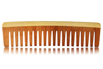Close-up of a wooden comb for hair care isolated on a white background with reflections 
