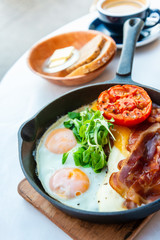 Grilled toasts served with beans, scrumbled eggs and sausage for an English breakfast.