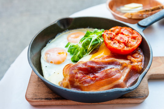 Grilled toasts served with beans, scrumbled eggs and sausage for an English breakfast.