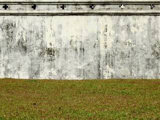 aged street white wall with lawn