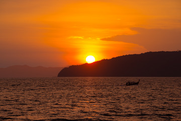Beautiful tropical sunset and traditional Thai boat silhouette, Ao-Nang, Krabi, Thailand