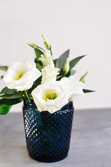 White flowers in classic blue glass. Lisianthus. Eustoma