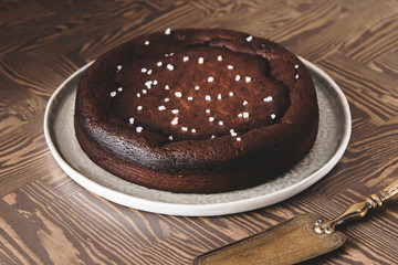 Moist Ginger Chocolate cake sprinkled with sea salt on wooden table. Selective focus. Haze effect