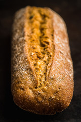 Freshly baked rustic bread on the rustic background. Selective focus. Shallow depth of field.