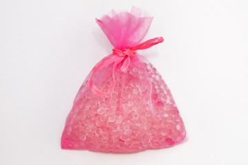 Pink pouch on a white background, flavor hanging in a car. Air fresheners are made in the form of flavored granules placed in bright sachets. Car air freshener with balls.