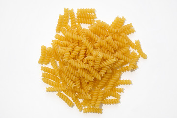 Spiral pasta on a white background. Uncooked italian pasta top view. Durum wheat pasta.